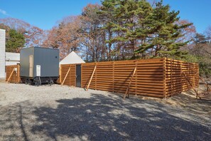 A building with a sloped roof and a fenced area. - ReSchool Nasu Glamp (Nasu)