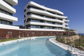Un bâtiment moderne doté de nombreux balcons et d’une piscine.