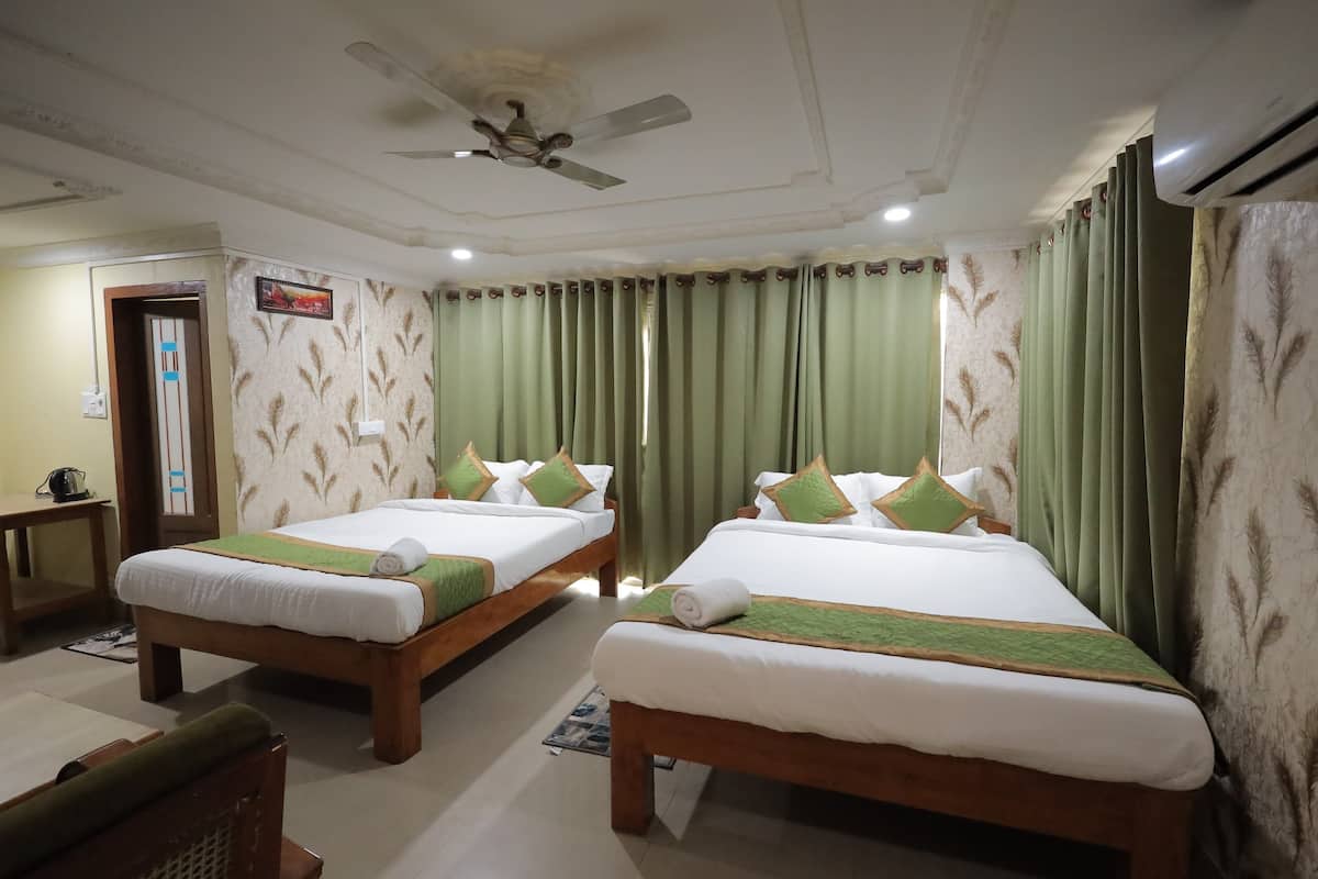 A hotel room with two beds, a ceiling fan, an air conditioner, and a door with a sign.