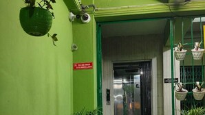 A hotel entrance with a green wall, a red carpet, and potted plants. - Hotel Pariwar Mahal (Guwahati)