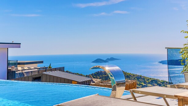 Una piscina infinita moderna con vistas despejadas al océano y a islas distantes.