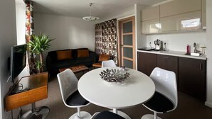 Un espacio habitable compacto con comedor, kitchenette y zona de estar.