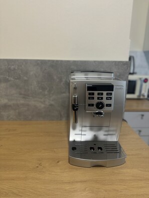 A stainless steel espresso machine on a wooden countertop.