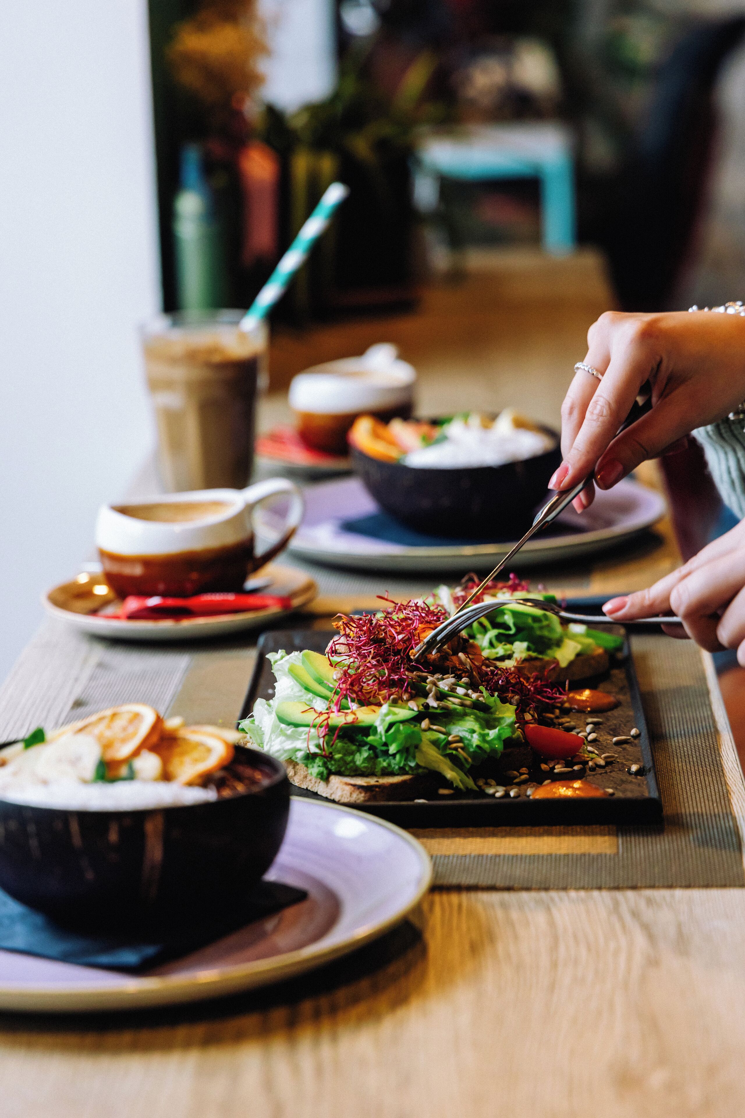 A dining table with various dishes, including a salad, a bowl of soup, and a cup of coffee.