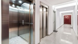 Un ascenseur moderne avec une finition métallique et un panneau de commande.