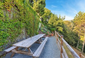 Relax in a serene garden setting with a picnic area and lush greenery.