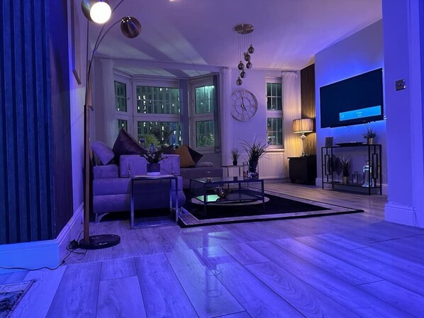 Una sala de estar moderna con un sofá, una mesa de centro y una lámpara de pie.