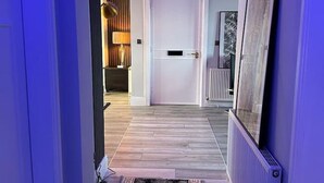 A hallway with a patterned rug, a white door, and a radiator on the wall.