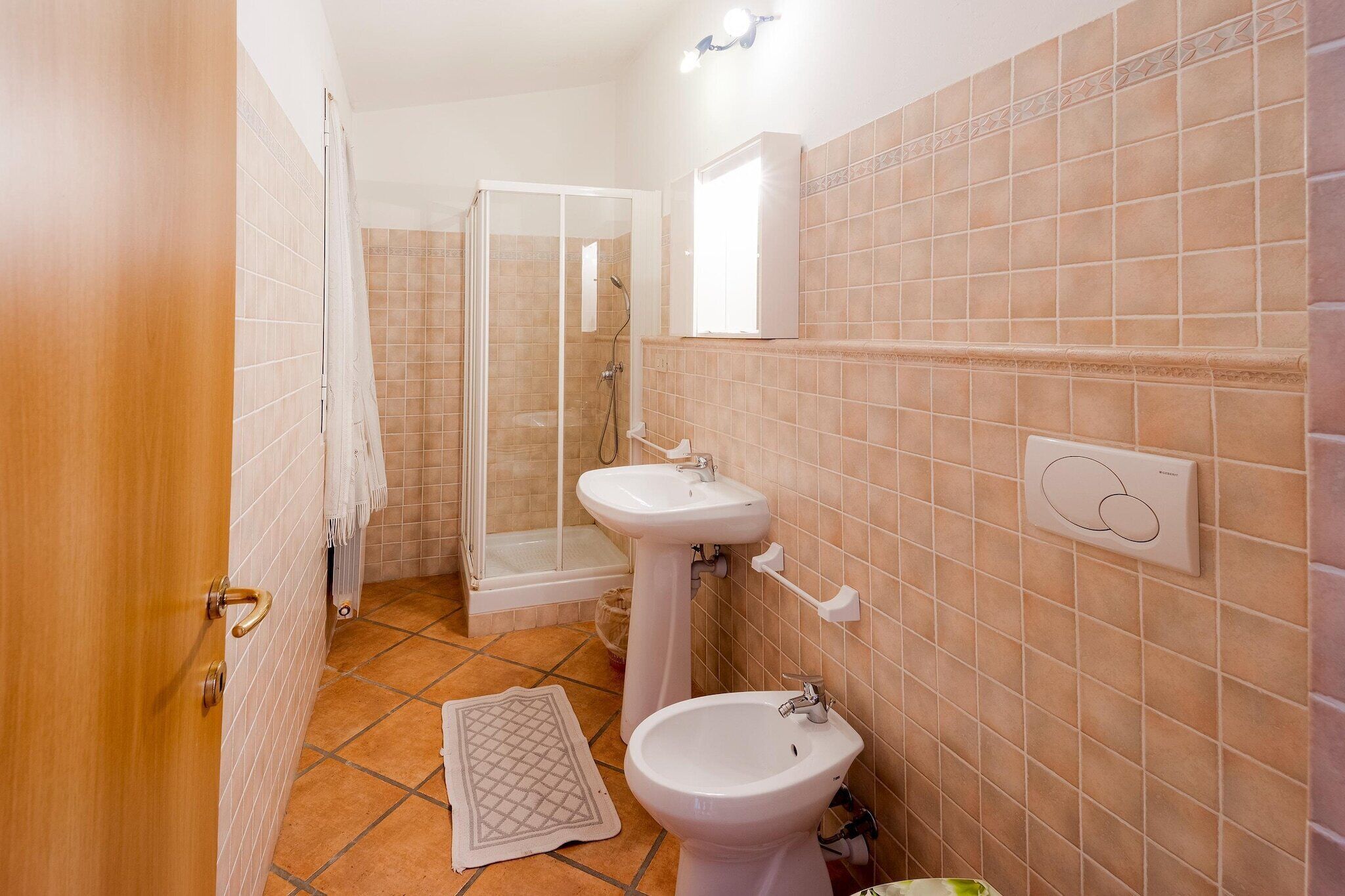 Ein Badezimmer mit Dusche, Waschbecken und Bidet.