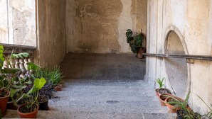 Un escalier étroit, bordé de chaque côté de pots de plantes, menant à un niveau supérieur.