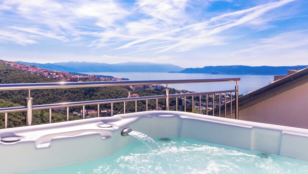 A hot tub on a balcony overlooking a lake and mountains. - Apartment Aqua-Juric (Crikvenica)