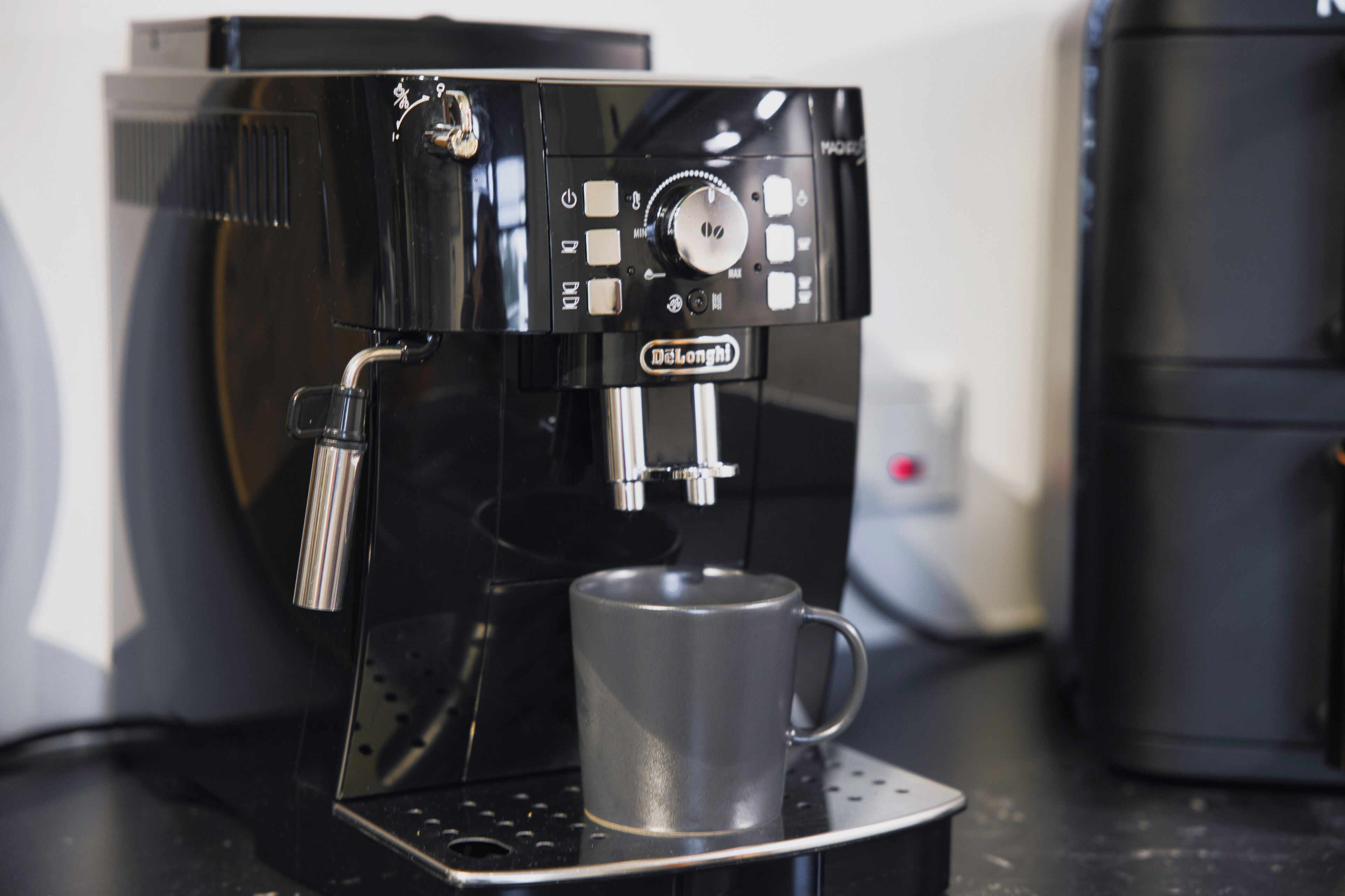 Eine Kaffeemaschine mit Bedienfeld und einer Tasse auf der Abtropfschale.