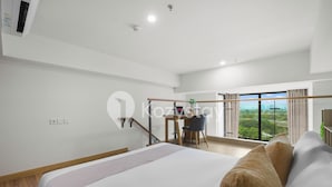 Ein modernes Hotelzimmer mit einem großen Bett, einem Schreibtisch und Blick ins Freie.