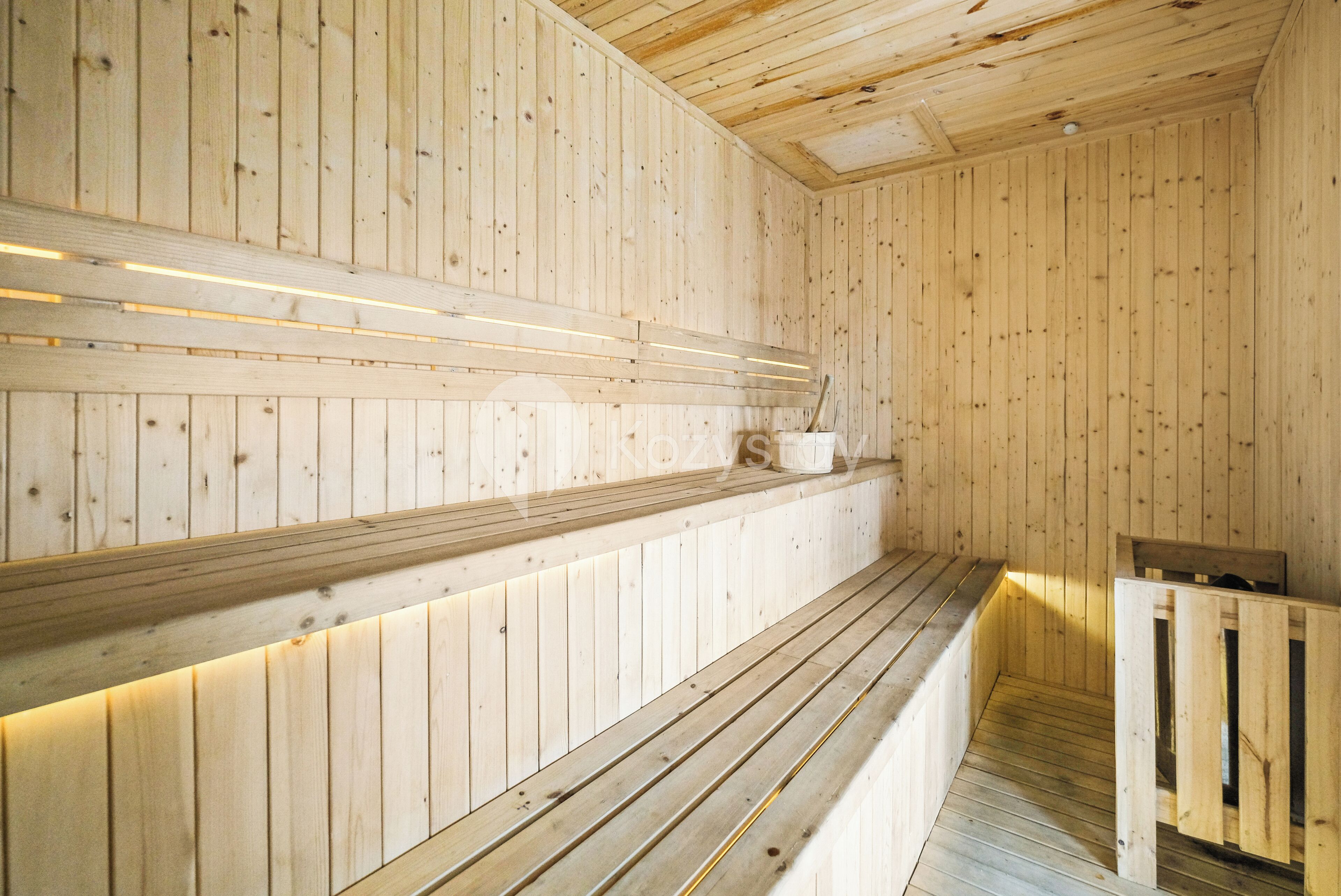 A wooden sauna with benches and a bench seat.