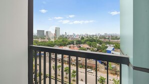 Ein Balkon mit Blick auf die Stadt, inklusive Gebäude und Grünflächen.