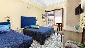 A hotel room with two beds, a desk, and a TV. - Lovely and typical apartment in the center of Sorrento (Campania)