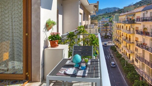 A balcony with a table, chairs, and potted plants. - Lovely and typical apartment in the center of Sorrento (Campania)