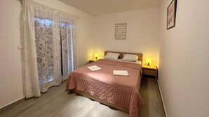 Un dormitorio con una cama, dos lámparas de noche, una ventana con cortinas y un cuadro en la pared.