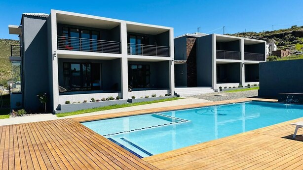 Ein modernes Gebäude mit Schwimmbad und Holzterrasse.