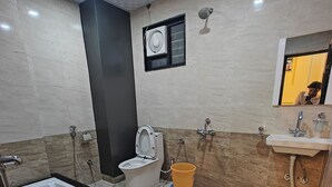 A modern bathroom with a large bathtub, a toilet, and a sink. - HOTEL PINK CITY (Sikar)