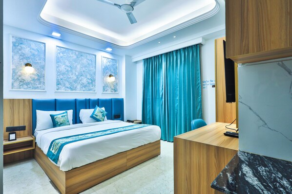 Une chambre d’hôtel moderne avec un grand lit, un bureau et une télévision.