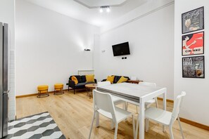 Una sala de estar moderna con un sofá, una mesa de centro y una mesa de comedor con sillas.