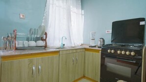 Une cuisine avec des meubles de rangement en bois, une cuisinière et un évier.