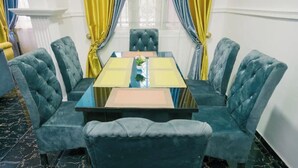 Un espace repas comprenant une table rectangulaire et six chaises rembourrées.