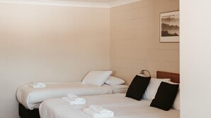 A hotel room with two beds, a flat-screen TV, and a painting on the wall. - 3 Share - 3 Share Room - Perisher Village Views (Perisher Valley)