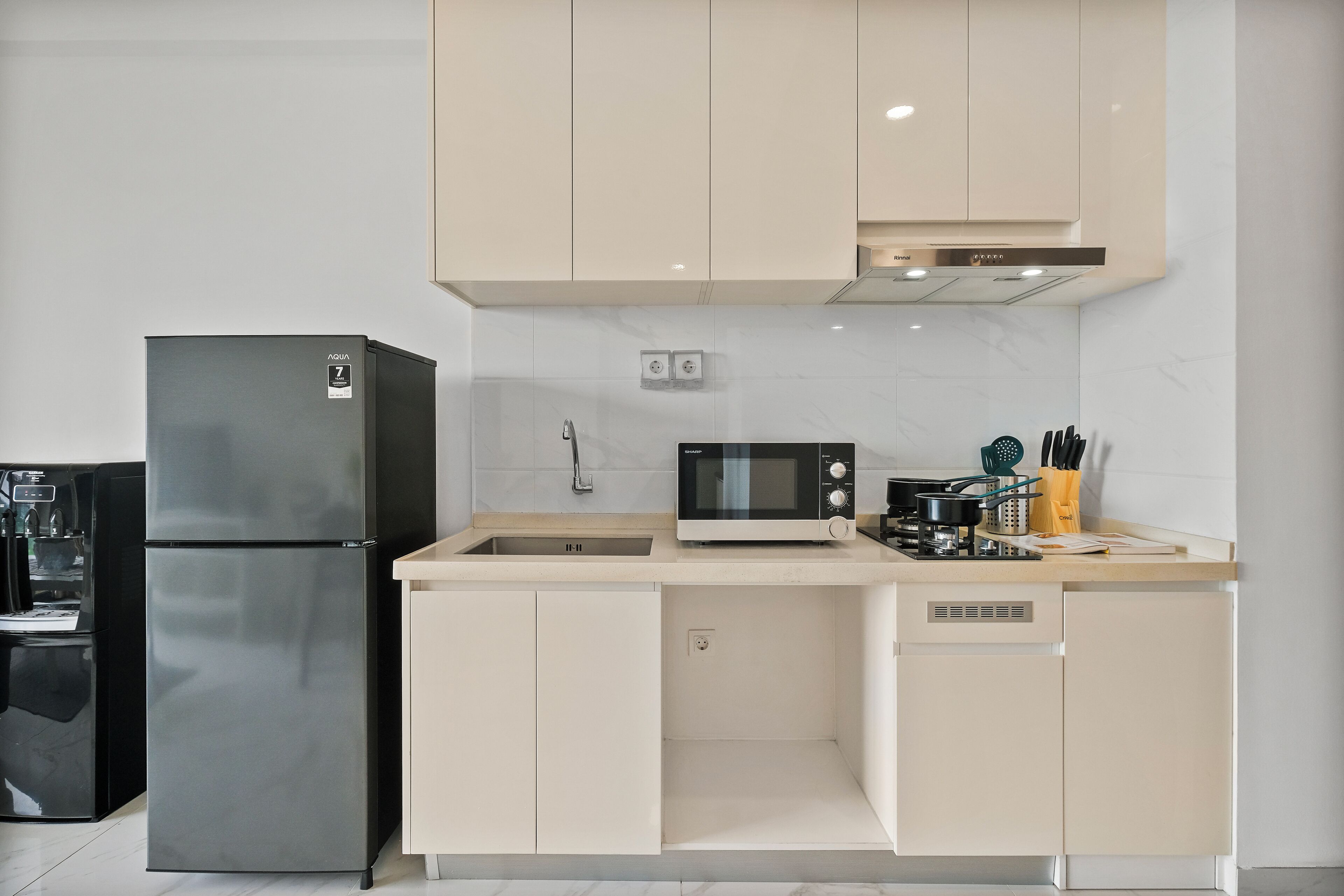 Une cuisine moderne équipée d’un réfrigérateur en acier inoxydable, d’un four à micro-ondes et d’une cuisinière.