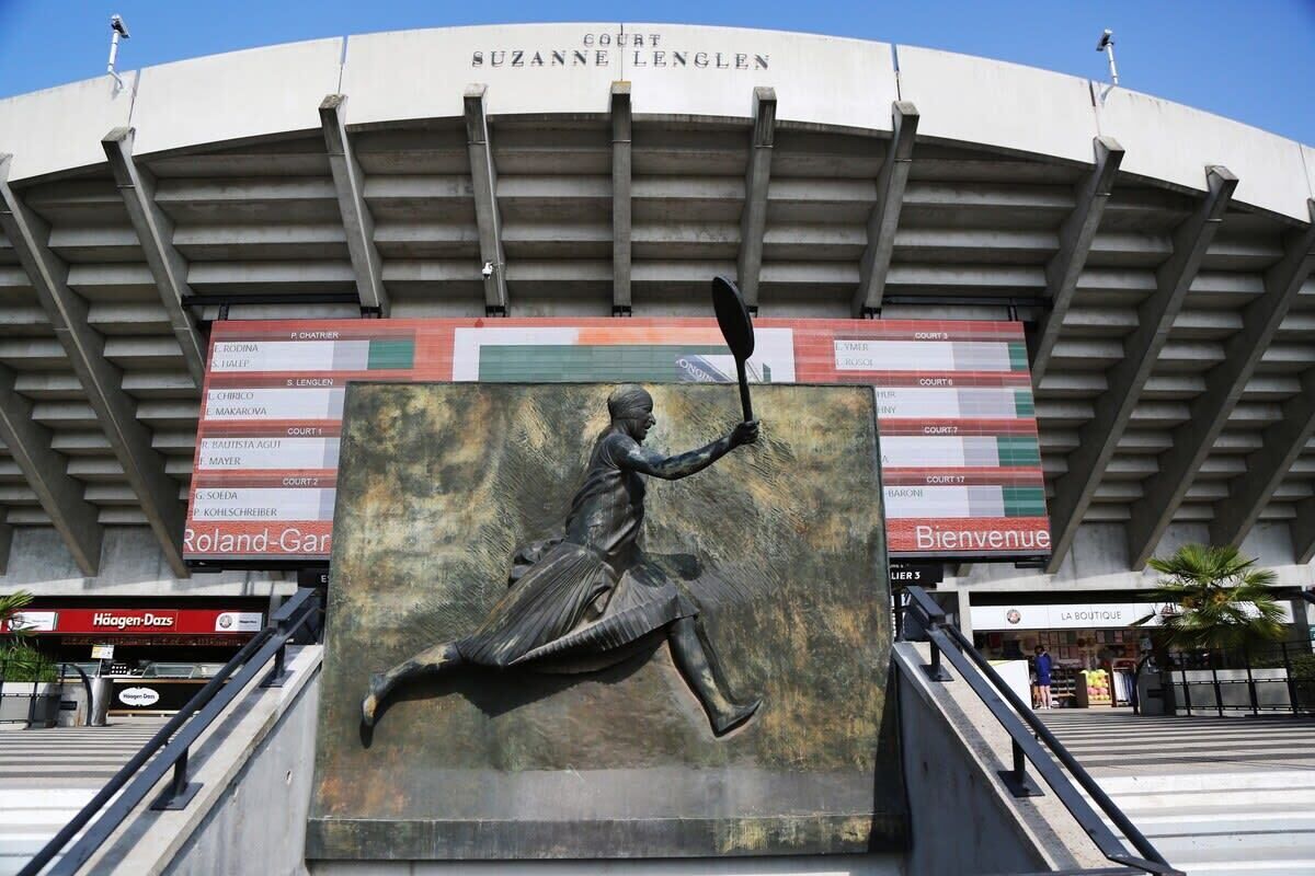 A stadium with a large bronze statue of a figure holding a flag, surrounded by multiple courts labeled with names.