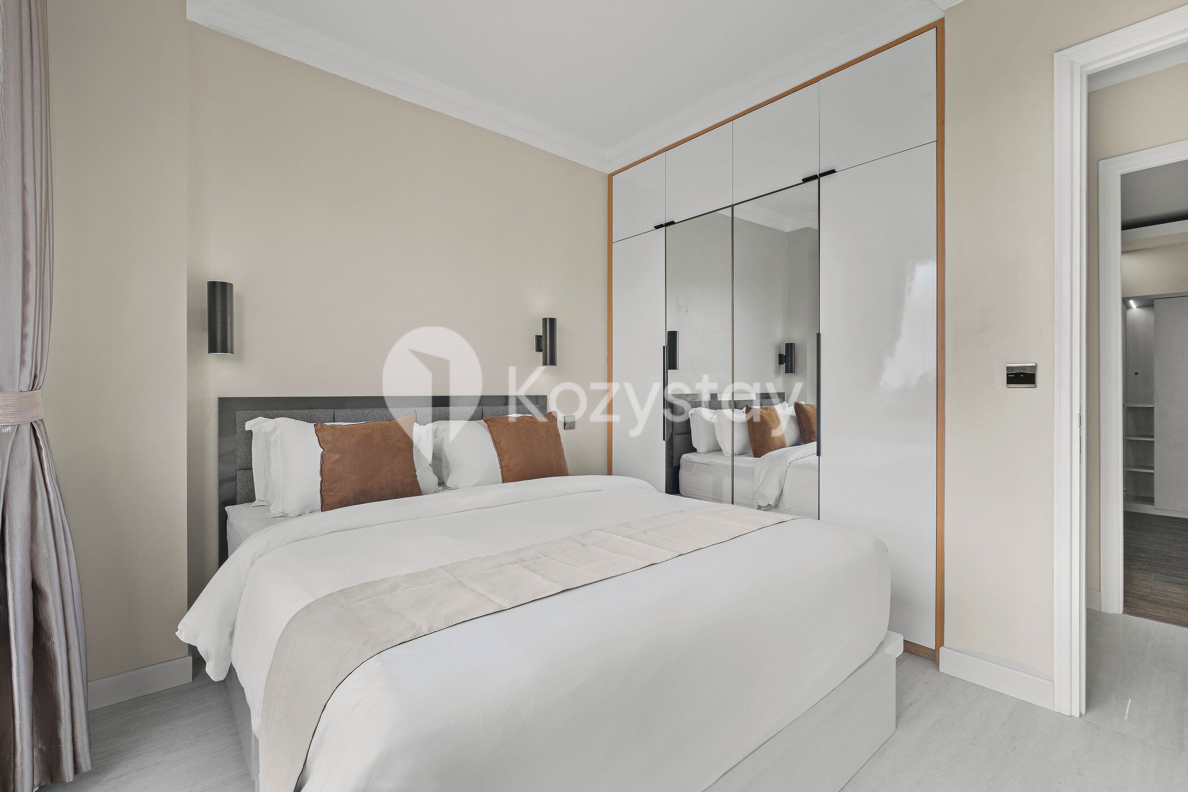 Un dormitorio moderno con una cama grande, un armario con espejo y un vestidor.