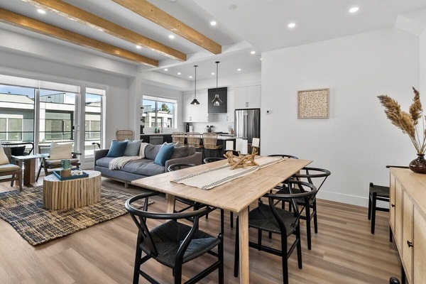 The dining table and chairs next to the open kitchen create the ideal setting for family meals, entertaining guests, or simply enjoying good company.