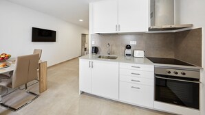A modern kitchen with white cabinetry, a stainless steel range, and a built-in oven. - Deluxe Studio Apartment 100 meters from the beach (Benidorm)