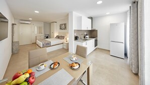A modern apartment with a dining area, kitchenette, and a bedroom. - Deluxe Studio Apartment 100 meters from the beach (Benidorm)