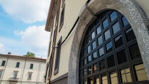 A building with a stone archway and a large window with multiple panes. - Suite JOIVY Lake 11 (Como)