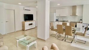 A modern apartment with a living room, dining area, and kitchen. - Deluxe Apartment 100 meters from the beach (Benidorm)