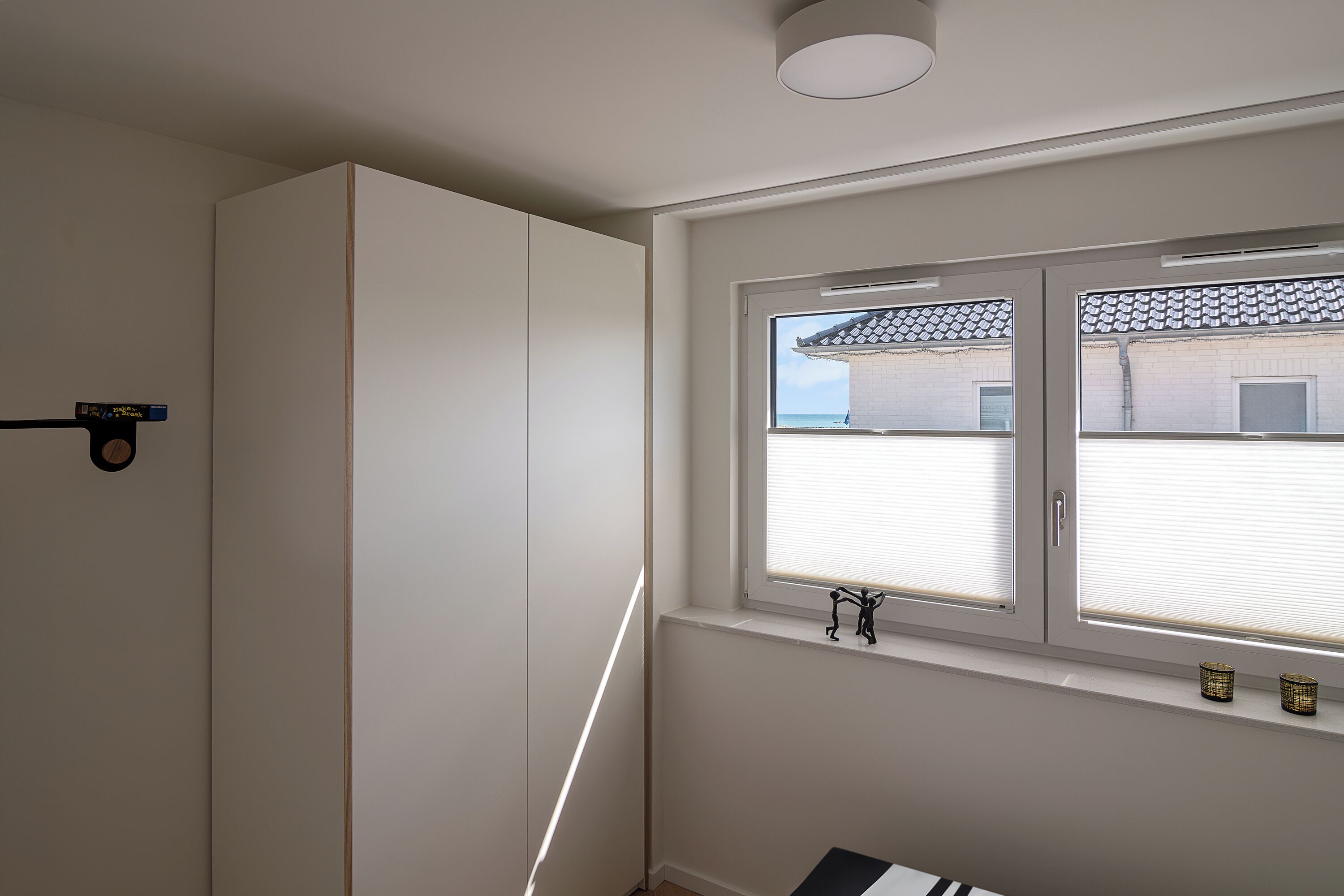 A room with a large window, a radiator, and a door with a black handle.