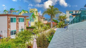 Una zona residencial con varias casas, incluyendo una casa amarilla de techo verde y una casa blanca con fachada de piedra.