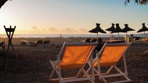 Two beach chairs with a view of the ocean and beach umbrellas in the background. - La Mouette et les Dromadaires (Essaouira)