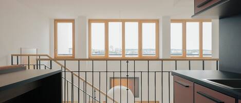 Una cocina moderna con ventanas amplias, una escalera y vistas a la ciudad.
