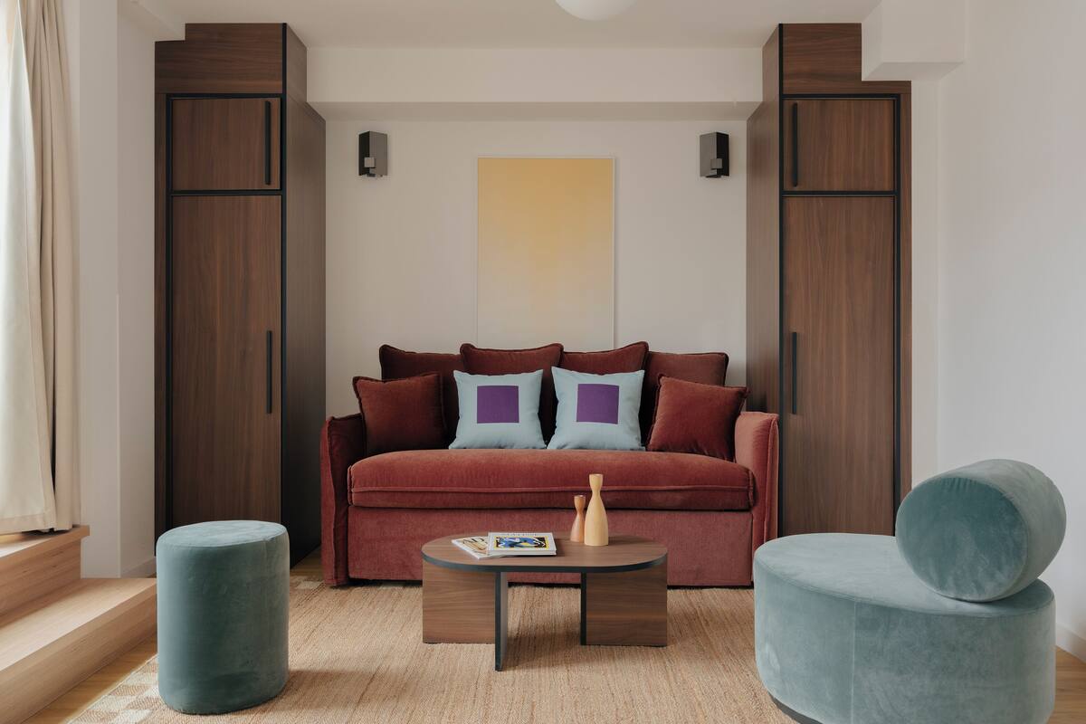 Un salon moderne comprenant un canapé, deux fauteuils, une table basse et un tapis.
