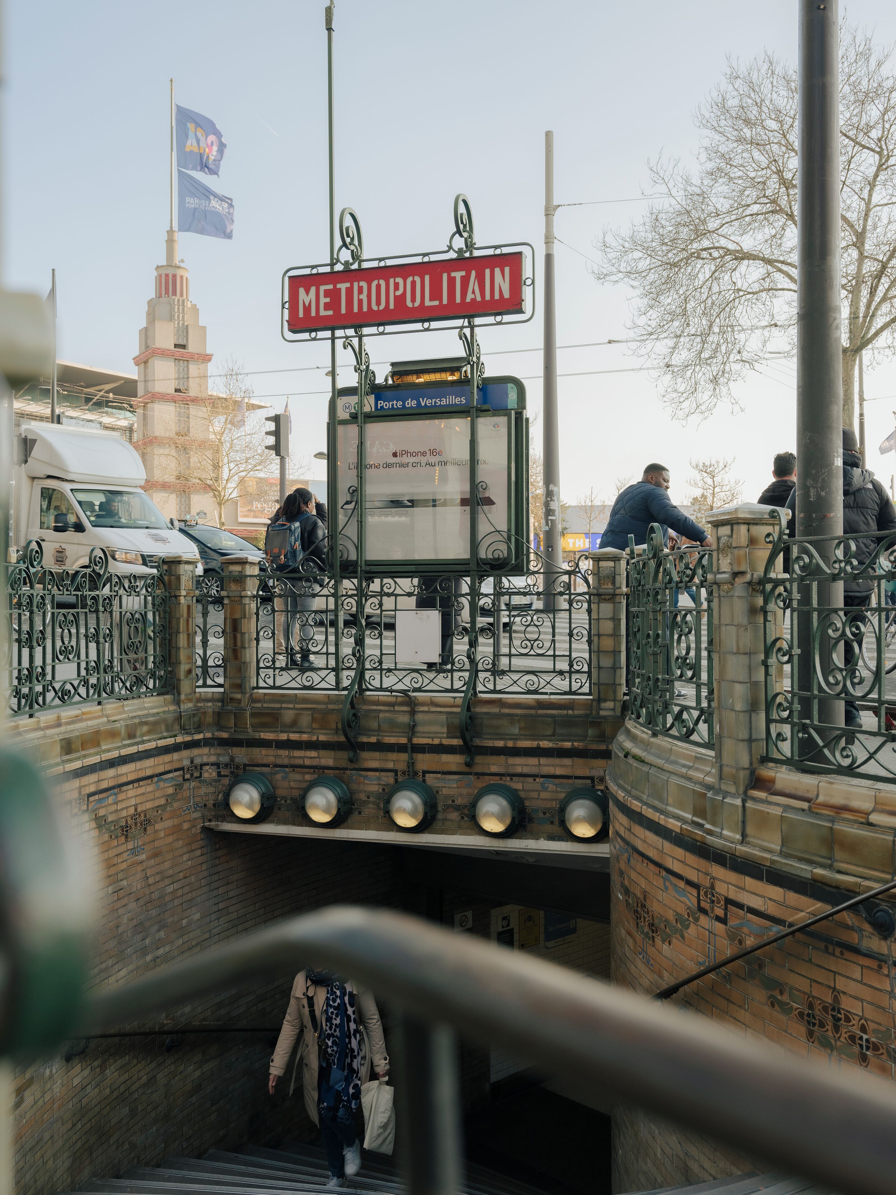 A pedestrian bridge with a sign reading "METROPOLITAIN" and a bus stop shelter.