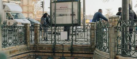 A pedestrian bridge with a sign reading "METROPOLITAIN" and a bus stop shelter.