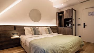 Een moderne slaapkamer met een groot bed, houten hoofdbord, nachtkastje en een inbouwkast.