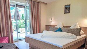 A hotel room with a bed, a table, and a view of the outdoors. - Lovely apartment for 6 guests with WIFI, TV, terrace and pets allowed (Mayrhofen)
