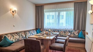 A dining area with a table, chairs, and a sofa. - Cosy apartment for 5 guests with WIFI, TV, balcony and pets allowed (Mayrhofen)