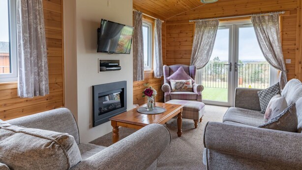 Una sala de estar acogedora con chimenea, asientos cómodos y televisor.