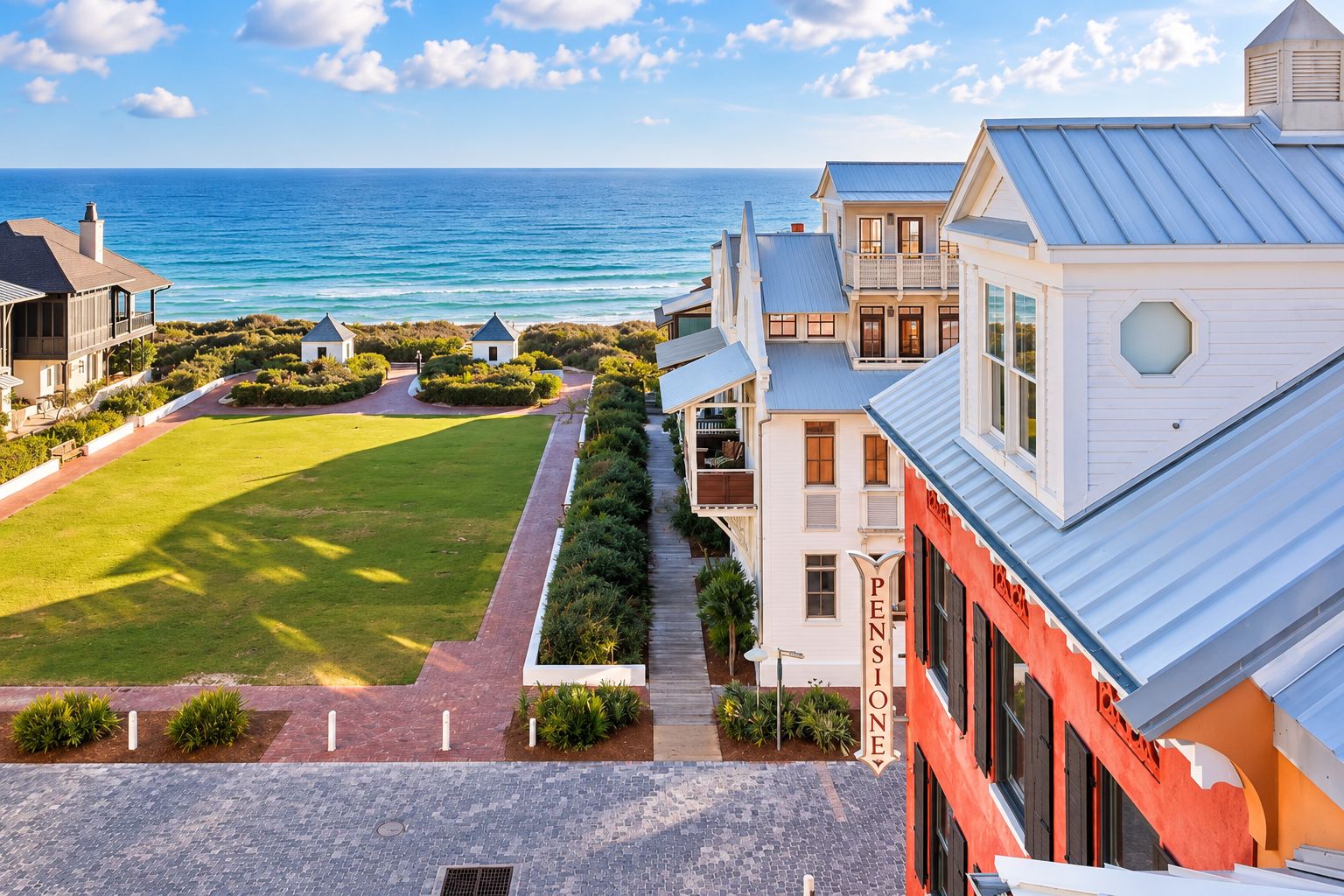 A coastal property with a view of the ocean, a paved pathway, and a well-maintained lawn.