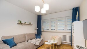 Uma sala de estar moderna com um sofá, uma mesinha redonda e um radiador.